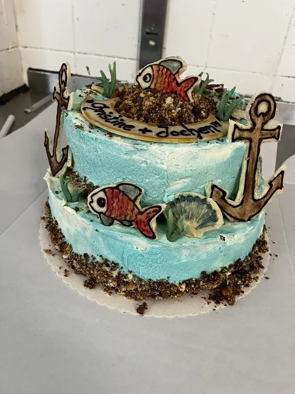 Zweistöckige Motivtorte mit maritimem Dekor: Anker, Fische und Schokostreusel