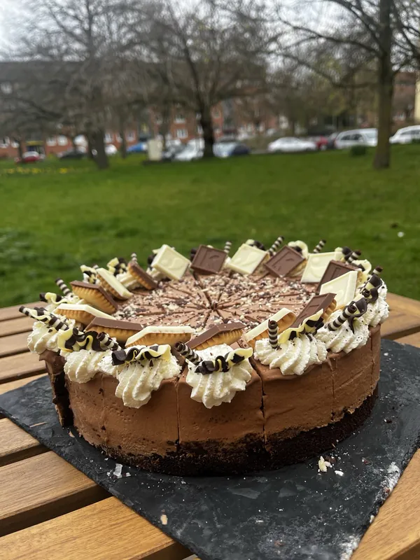Schokoladen-Sahnetorte auf einem Holztisch im Außenbereich von Mo's Café