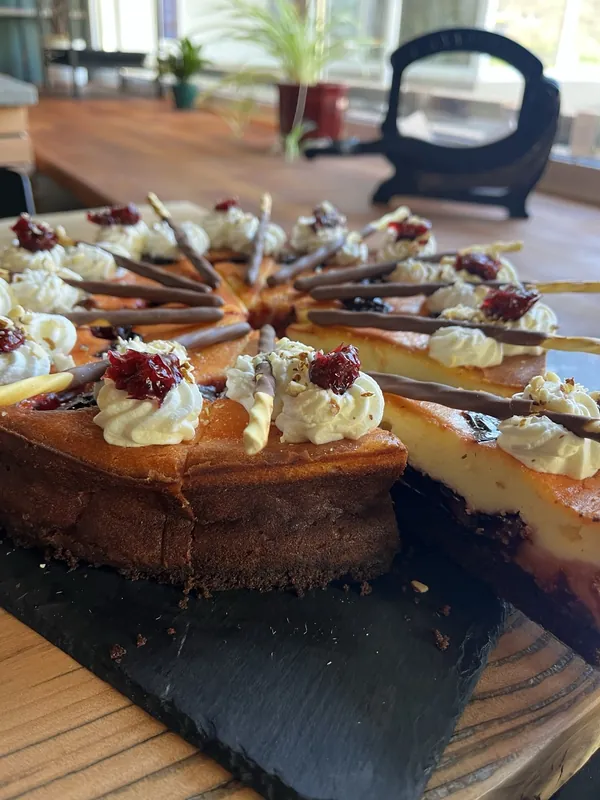 Angeschnittene Sahnetorte mit Schokoladendekor am Fensterplatz im Café