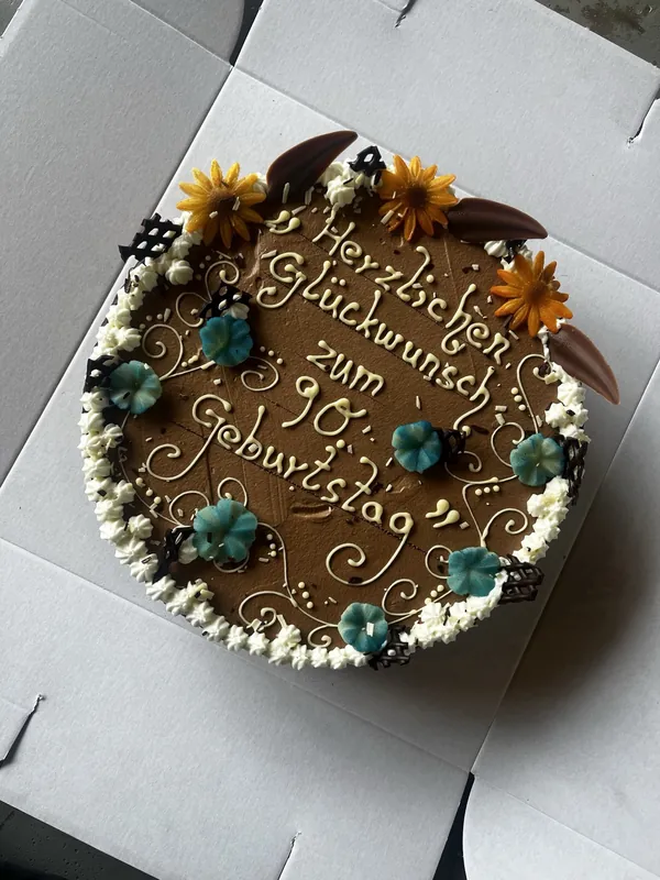 Geburtstagstorte mit Schriftzug „Herzlichen Glückwunsch zum 30. Geburtstag“ und Sonnenblumendekor, fertig zur Abholung